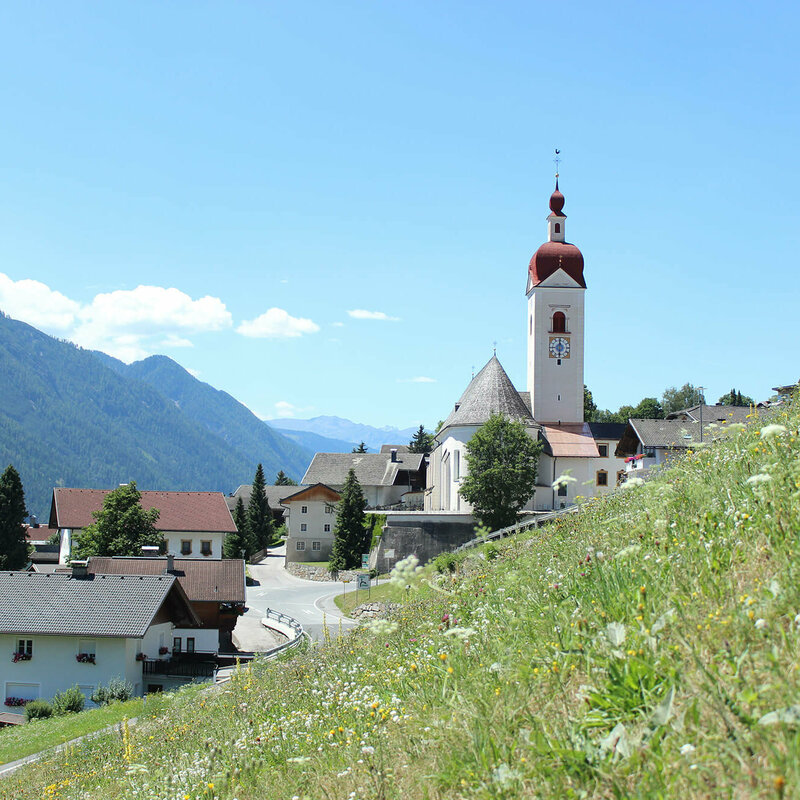 Assling Ortsansicht von Assling mit einer sommerlichen Wiese im Vordergrund