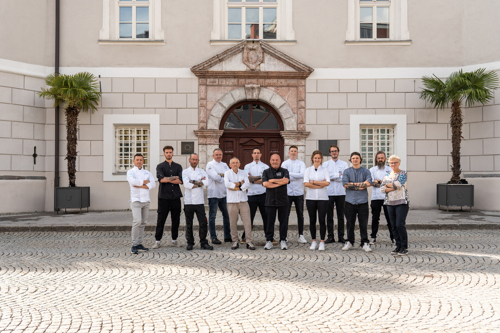 Die Köchinnen und Köche von Osttirol de luxe 2025 in klassischer Kochbekleidung vor der Lienzer Liebburg.